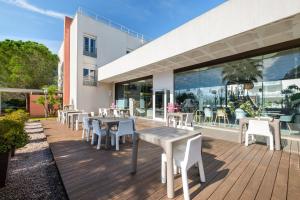 a patio with tables and chairs on a wooden deck at Comfort Aparthotel Antibes Le Maestria in Antibes