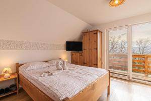 1 dormitorio con cama y ventana grande en Vineyard Cottage Rataj 2 Wellness - Happy Rentals, en Novo Mesto