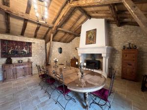 a dining room with a table and a fireplace at Le Relais des Chevaliers "La Suite des Seigneurs" in Cordes-sur-Ciel