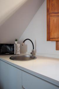 a kitchen counter with a sink and a microwave at Arsenal 31 by Seaward Suites in Villajoyosa