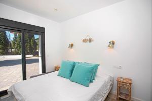 een slaapkamer met een bed met blauwe kussens erop bij Casa Scorpio in Jávea +12 foto's