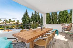 een houten tafel en stoelen op een balkon bij Casa Scorpio in Jávea