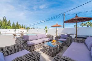 een patio met rieten meubels en parasols bij Casa Scorpio in Jávea