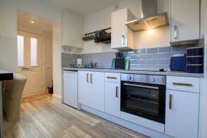 uma cozinha com armários brancos e um forno em Moray Court Chester City Centre Studio Apartment by Rework Accommodation em Chester