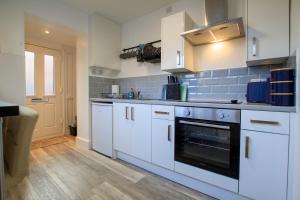 チェスターにあるMoray Court Chester City Centre Studio Apartment by Rework Accommodationの白いキャビネットとオーブン付きのキッチン