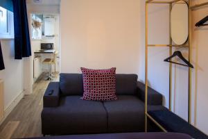 a living room with a blue couch with a red pillow at Moray Court Chester City Centre Studio Apartment by Rework Accommodation in Chester