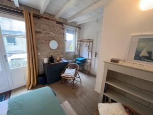 Habitación con cama, escritorio y ventana. en La Bonne Brise, en Grandcamp-Maisy