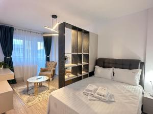 a bedroom with a bed and a table and a chair at Luxury Collection Studios at Q Residence Palas Mall in Iaşi