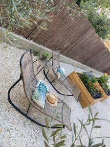 een stoel met een hoed in een tuin bij Villa Maya - 3 Groussan - Avignon - CLIM - TERRASSE in Avignon
