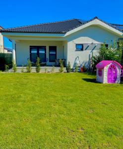 a house with a pink door in a yard at Rental house in Dumbrăviţa