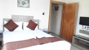 una camera con un grande letto e una televisione di ROYAL RIVIERA HOTELS & RESORTS ad Alleppey
