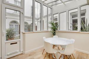 パリにあるPick a Flat's Apartment in le Marais -Camvdt2のダイニングルーム(白いテーブル、椅子、窓付)