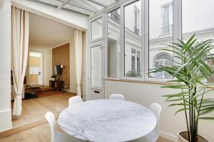パリにあるPick a Flat's Apartment in le Marais -Camvdt2の窓付きの客室で、白いテーブルと椅子が備わります。
