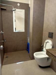 a bathroom with a toilet and a shower at Beechwood Holiday Apartments in Mussoorie