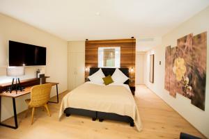 a bedroom with a large bed and a desk and a television at Rebers Pflug in Schwäbisch Hall +84 photos