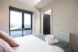 1 dormitorio con cama blanca y ventana grande en 4Bed, 3.5Bath House near National Stadium, Dublin en Dublín
