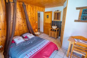 - une chambre avec un lit dans une pièce dotée de murs en bois dans l'établissement La Savoyarde, à Châtel