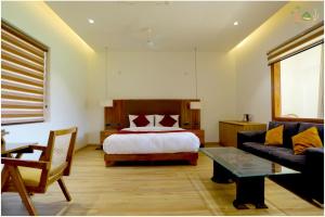 Sahib Farms and Resorts في دلهي: غرفة نوم بسرير واريكة