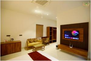 a living room with a couch and a tv at Sahib Farms and Resorts in Delhi
