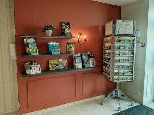 a corner of a store with shelves and books at Hôtel-restaurant Les Colonnades in Saint-Fulgent