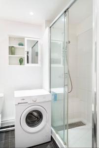 a washing machine in a bathroom with a shower at Appartement 75006 paris ! in Paris