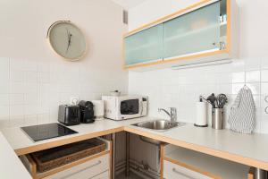 a kitchen with a sink and a clock on the wall at Appartement 75006 paris ! in Paris