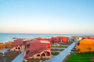 Pickalbatros Vita Resort - Portofino Marsa Alam في أبو دباب: اطلالة جوية على مدينة مع المحيط