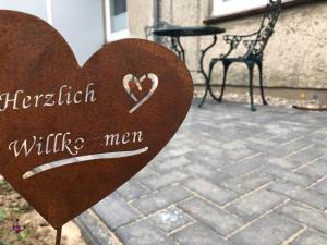 um sinal de coração de madeira num pátio de tijolos em Allis Kajüte em Lübeck
