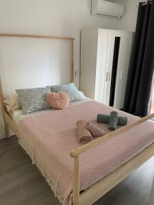 - un lit avec une couverture rose et des oreillers dans l'établissement joan miro, à Torremolinos