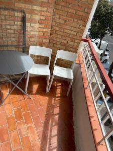 - 2 chaises blanches et une table sur la terrasse dans l'établissement joan miro, à Torremolinos