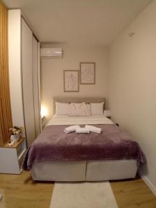 een slaapkamer met een groot bed en 2 handdoeken bij Blue apartment in Budva
