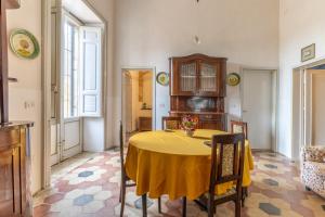 a dining room with a yellow table and chairs at The Holiday And Art Seahorse House in Vittoria