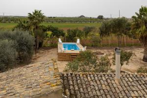 a swimming pool in a yard with a brick wall at The Holiday And Art Seahorse House in Vittoria
