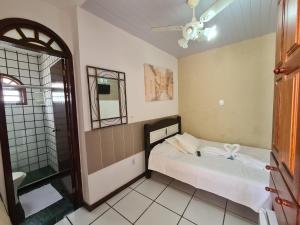 a small bedroom with a bed and a mirror at Pousada Aquários in Cabo Frio