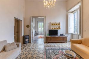 a living room with a couch and a tv at The Holiday And Art Seahorse House in Vittoria
