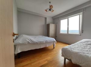 1 dormitorio con 2 camas y ventana en Sunset View Apartment Shkodër Rooftop, en Shkodër