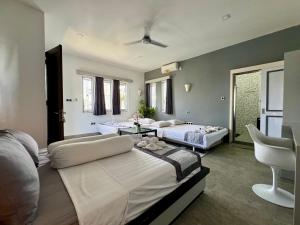 um quarto com duas camas e uma cadeira. em Villa Rumah Putih Abu Abu em Senggigi