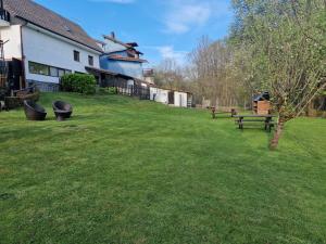 um quintal relvado com bancos e um edifício em alojamiento con jardin y barbacoa em Cangas de Onís