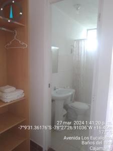 a bathroom with a white toilet and a sink at Wayra Hospedaje in Cajamarca