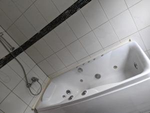 a white bath tub in a white tiled bathroom at Nepalaya Ferienwohnung in Pegnitz +5 photos