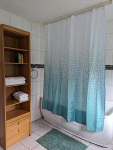 a bathroom with a shower curtain and a tub at Nepalaya Ferienwohnung in Pegnitz