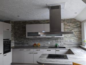 a kitchen with white cabinets and a stove top oven at Nepalaya Ferienwohnung in Pegnitz