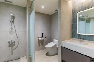 La salle de bains est pourvue de toilettes, d'un lavabo et d'une douche. dans l'établissement voco Chiayi, an IHG Hotel, à Chiayi