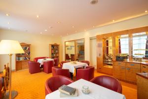 un restaurante con 2 mesas y sillas rojas en Arkona Strandhotel en Binz