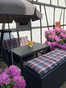 einen Pavillon mit einem Tisch, einem Sonnenschirm und Blumen in der Unterkunft Apartment mit Wintergarten und Terrasse in ruhiger Lage im schönen Taunus in Glashütten