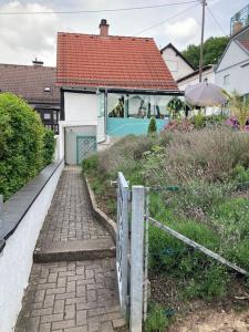 ein Haus mit einem Tor und einem Backsteinsteg in der Unterkunft Apartment mit Wintergarten und Terrasse in ruhiger Lage im schönen Taunus in Glashütten