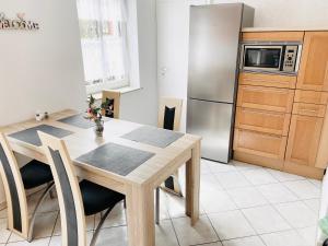 a kitchen with a table and a stainless steel refrigerator at Ferienwohnungen Grimma 5 in Grimma