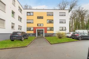 a building with cars parked in a parking lot at Business-Apartment in Lippstadt in Lippstadt