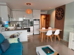 a kitchen and living room with a blue couch and a table at Almadrava Beach in Roses