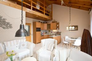 ein Wohnzimmer mit weißen Stühlen und einem Tisch in der Unterkunft Bungalow Seestern - b47691 in Malchow